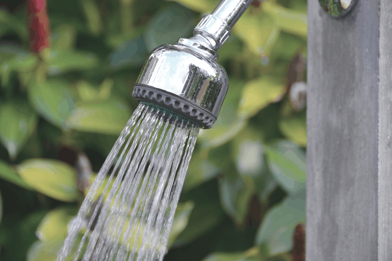 Outdoor shower head spraying water.